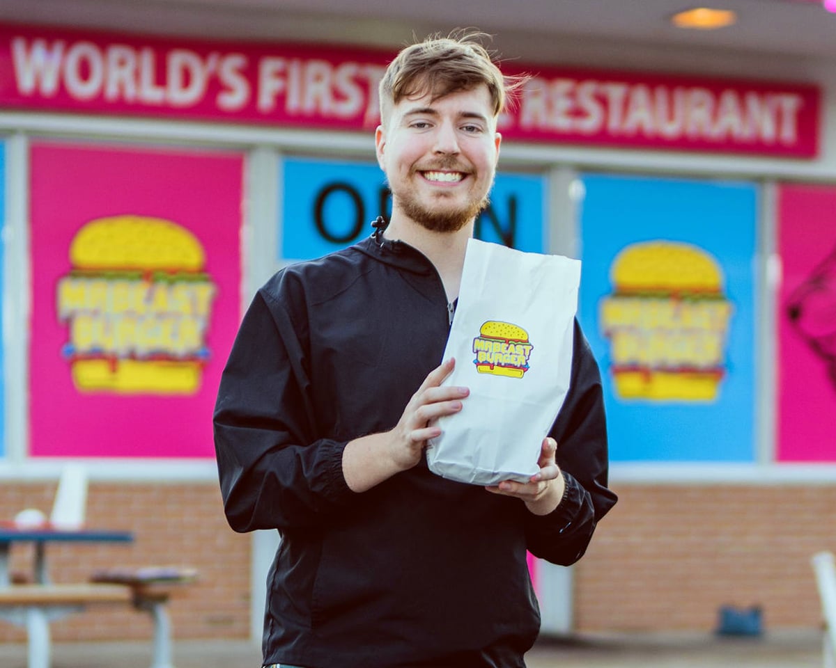 Mr Beast smiling and holding a bag of food